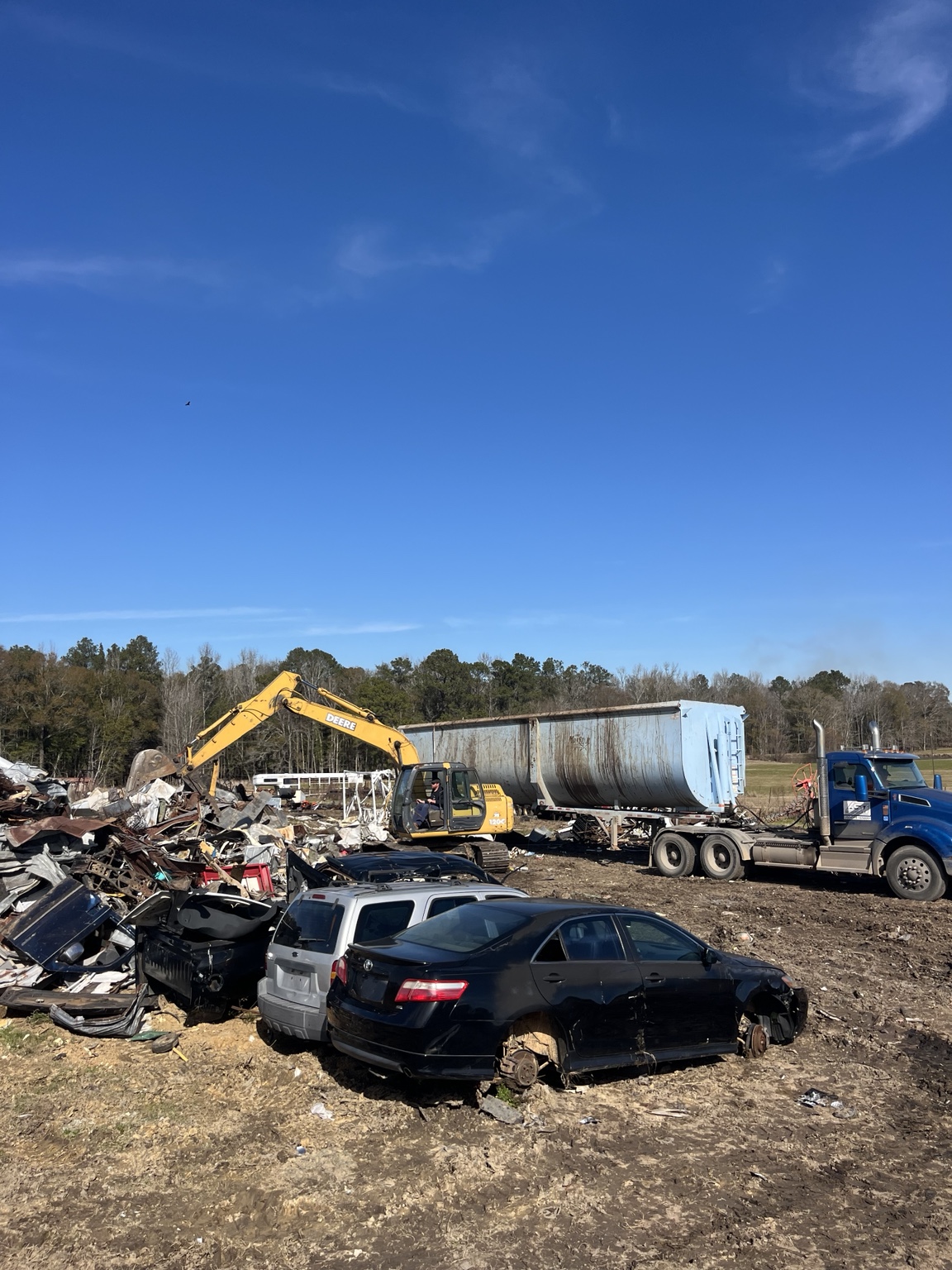 Busby Wrecking scrapyard with excavator and scrap metal